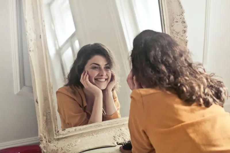 Woman smiling into a mirror